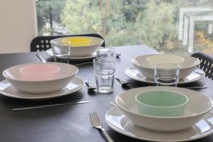 uma mesa preta com pratos, taças e copos em Spacious and calm apartment in Montrouge - Welkeys em Montrouge