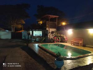 a swimming pool in a backyard at night at Pousada Flor da Chapada in Chapada dos Guimarães