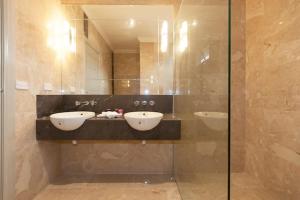 a bathroom with two sinks and a glass shower at The Grand Manor in Pomonal +13 photos