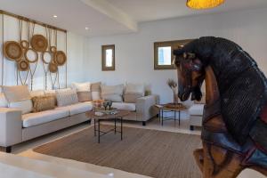 a living room with a couch and a horse head statue at Amalgam Homes Paros in Ambelas