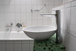 a bathroom with a sink and a bath tub at Aparthotel Domizil in Borkum