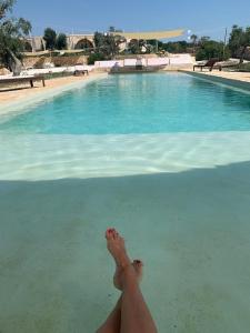 una persona tirada en el agua junto a una piscina en masseria a libeccio, en Maruggio