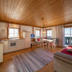 Una cocina y una sala de estar con mesa y sillas. en Appartement Ferienhof Ortnergut, en Eben im Pongau
