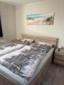 a bedroom with two beds and a painting on the wall at Ferienwohnung-Maxi in Borkum