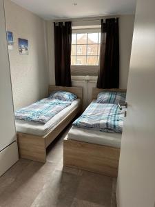 two beds in a small room with a window at Ferienwohnung-Maxi in Borkum