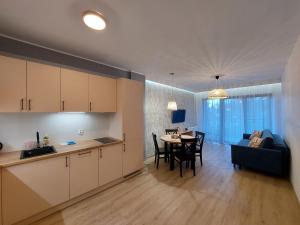 a kitchen and living room with a table and a couch at Apartament Pod Papugami 2 Karpatia Resort in Karpacz