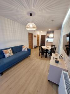 sala de estar con sofá azul y mesa en Apartament Pod Papugami 2 Karpatia Resort en Karpacz