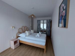 a bedroom with a large bed with white sheets at Apartament Pod Papugami 2 Karpatia Resort in Karpacz