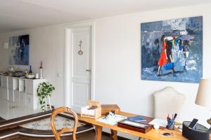 un escritorio en una habitación con una pintura en la pared en Le Stanze di Sissi - Luxury Suites, en Nápoles