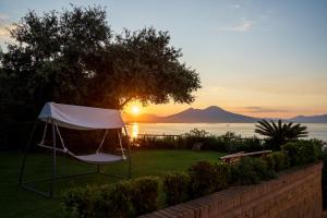 - un kiosque dans la cour avec le coucher du soleil en arrière-plan dans l'établissement Le Stanze di Sissi - Luxury Suites, à Naples
