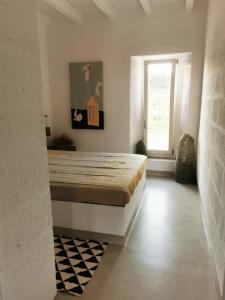 1 dormitorio con cama y ventana en masseria a libeccio, en Maruggio