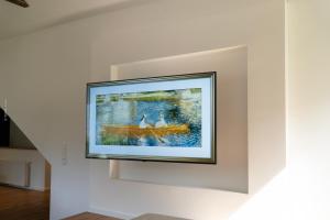 a painting of two dogs in a boat on a wall at Chalet Schmelz Huette mit Sauna und Garten in Flattach