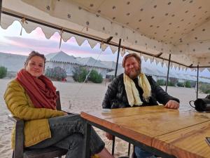 Ein Mann und eine Frau sitzen an einem Tisch in der Unterkunft Night Stay Camp in Jaisalmer