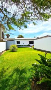 a large yard with a white building and a grass yard at Tiende Laan Bed & Breakfast and Self-Catering in Walvis Bay