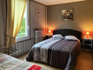 Schlafzimmer mit einem Bett und einem Fenster in der Unterkunft Hôtel l'Annexe in Moux-en-Morvan