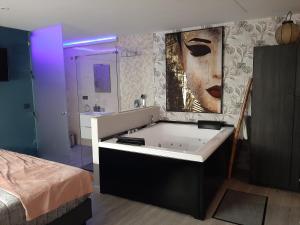 baño con bañera y pintura en la pared en Apartamento Sierra Lof Paraiso, en Ubrique