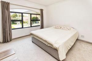 a bedroom with a bed and a large window at Modern 4 bedroom residential villa with pool, fully solar powered in Sandton
