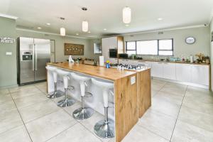 una cocina con una gran isla con taburetes de bar en Modern 4 bedroom residential villa with pool, fully solar powered en Sandton
