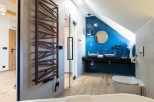 ein Bad mit einem WC und einer blauen Wand in der Unterkunft Penzion Monner in Mikulov