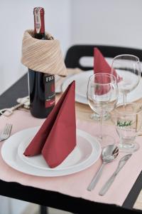 ein Tisch mit einem weißen Teller mit einer Flasche Wein in der Unterkunft Drabika Apartment Balcony & Private Parking Wrocław by Noclegi Renters in Breslau