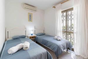dwa łóżka w pokoju z oknem w obiekcie Tropicana Townhouse, 2 bedroom w mieście Nerja