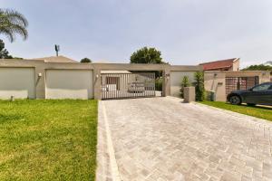 a driveway with a gate in front of a house at Modern 4 bedroom residential villa with pool, fully solar powered in Sandton
