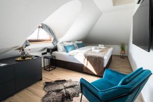 - une chambre avec un lit et une chaise bleue dans l'établissement Penzion Monner, à Mikulov