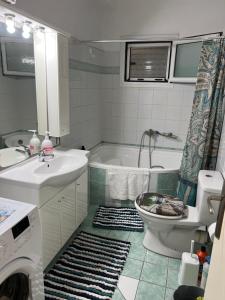 a bathroom with a tub and a toilet and a sink at Apartment Mitrou 2 in Loutra Oraias Elenis 