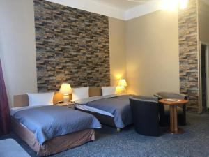 a hotel room with two beds and a brick wall at Hotel Castell am Kurfürstendamm in Berlin