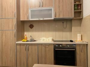 una cocina con armarios de madera y fregadero en Apartment SIDRO Tivat, en Tivat