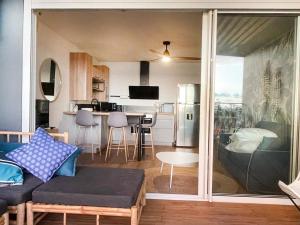 Il comprend un salon avec un canapé et une table. dans l'établissement Le Pétrel Bleu - Appartement sur la plage des Tortues à Saint-Leu, à Saint-Leu