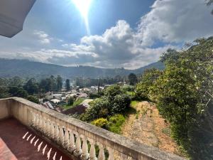 uma vista da varanda de uma casa com o sol a brilhar em Home Holiday em Nuwara Eliya