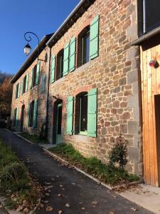 un edificio de ladrillo con puertas verdes y una calle en Fleurs de lin, 