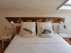 a bed with two pillows and a wooden headboard at LA VIE EST BELLE 