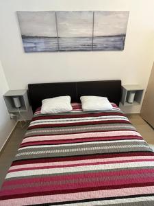 een bed met een gestreepte deken en 2 kussens bij Apartment Lucija in Šimuni