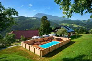 - une vue sur la piscine avec une terrasse et une maison dans l'établissement Domačija Metul, à Luče
