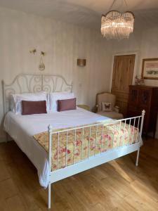 a bedroom with a white bed and a chandelier at La Dovecote Sarlat in Sarlat-la-Canéda