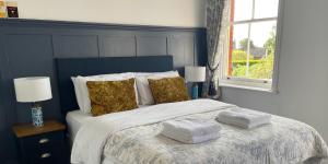 a bedroom with a bed with towels on it at Portman Lodge in Blandford Forum