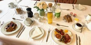uma mesa branca com pratos de comida para o pequeno almoço em Portman Lodge em Blandford Forum