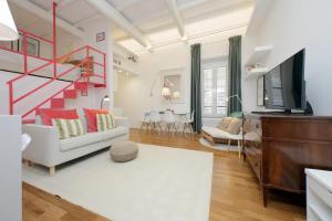 a living room with a couch and a television at 4BNB - Serpenti Delightful Apartment in Rome +30 photos