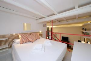 a large white bed in a room with a tv at 4BNB - Serpenti Delightful Apartment in Rome