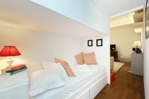 a white bed in a room with a red lamp at 4BNB - Serpenti Delightful Apartment in Rome