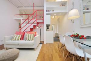 a living room with a white couch and a red staircase at 4BNB - Serpenti Delightful Apartment in Rome