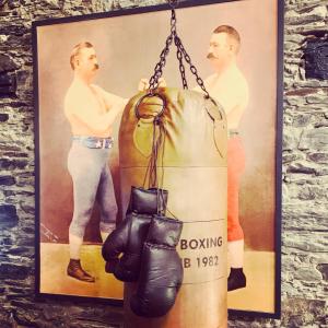 a pair of boxing gloves hanging on a wall at Loft 11 Stunning LUXURY NYC Loft Style Interior Designed 2BD Apartment EXCELLENT CITY CENTRE LOCATION Mezzanine Cinema Room Designer Furniture AMAZING SPACE in Douglas