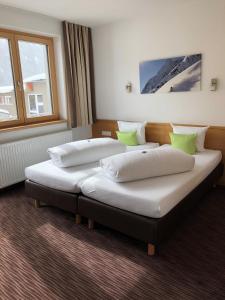 two beds in a room with two windows at Arlenweg in Sankt Anton am Arlberg