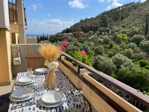 a table with plates and flowers on a balcony at Argentario Holiday Home in Porto Santo Stefano