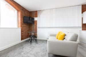 a living room with a white couch and a tv at Platform City Theatre Studio with Secure Parking in Hull