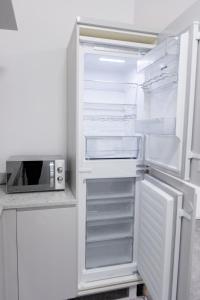 an empty refrigerator with its door open and a microwave at Platform City Theatre Studio with Secure Parking in Hull