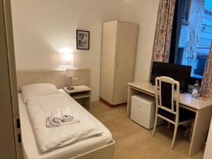 a small room with a bed and a desk with a computer at Hotel City Check In - günstig & flexibel Tageweise und Wochenweise möglich in Heiligenhaus +16 photos