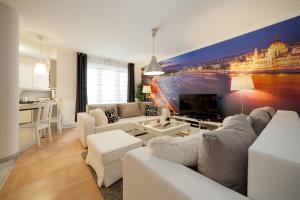 ein Wohnzimmer mit einem Sofa und einem TV in der Unterkunft GDE Holló Apartments in Budapest